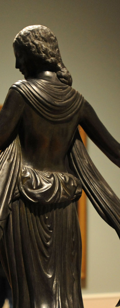Bronze sculpture of woman with deer indoors