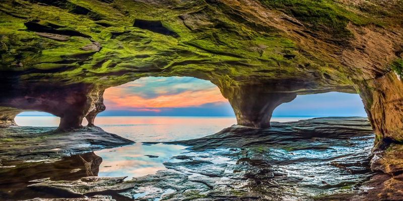 Scenic cave with sunset over water