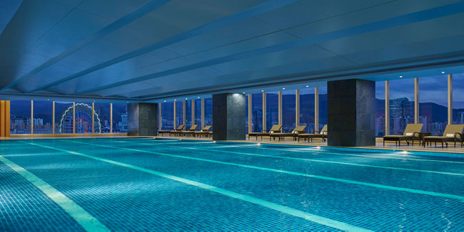 Modern indoor rooftop swimming pool at dusk