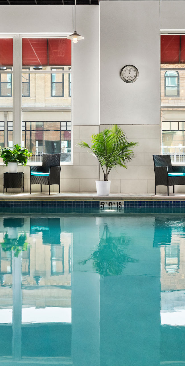 Indoor pool with seating and large windows