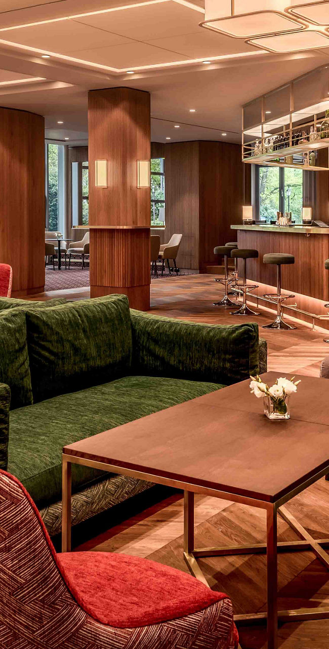 Modern hotel lounge with bar and green sofas