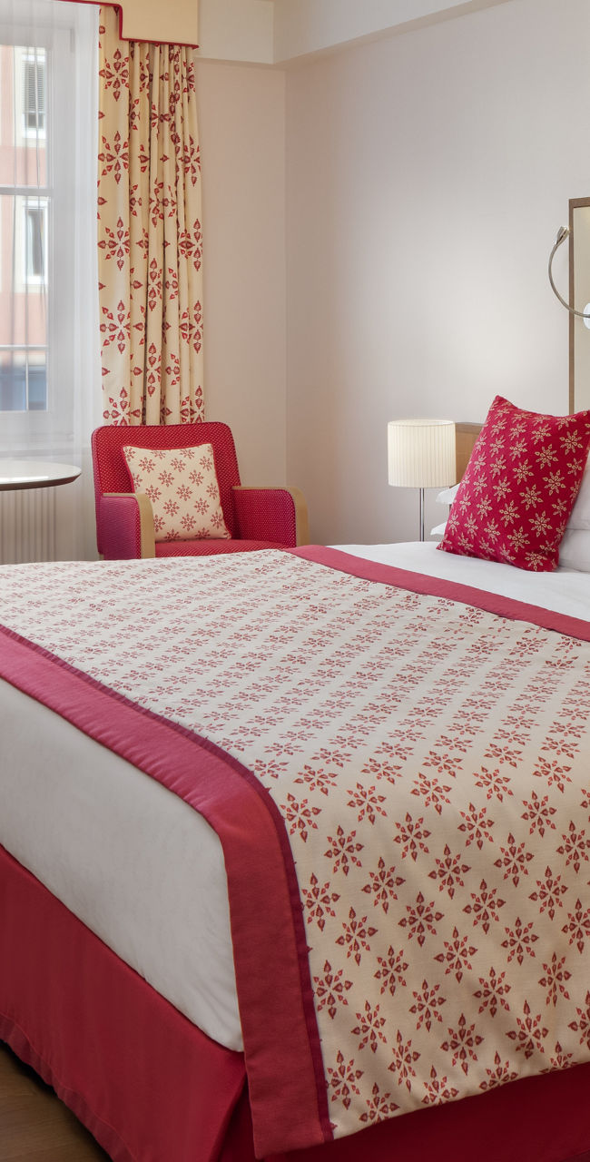 Modern hotel room with red accents and double bed