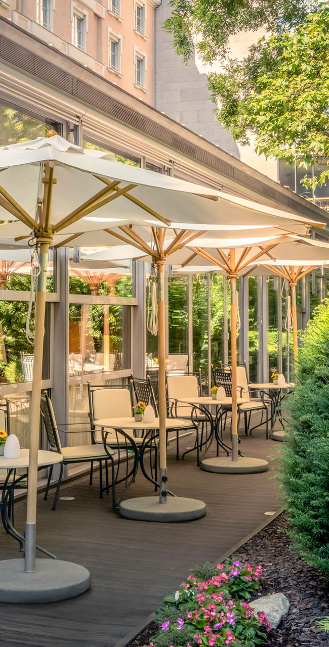 Outdoor café terrace with umbrellas and greenery