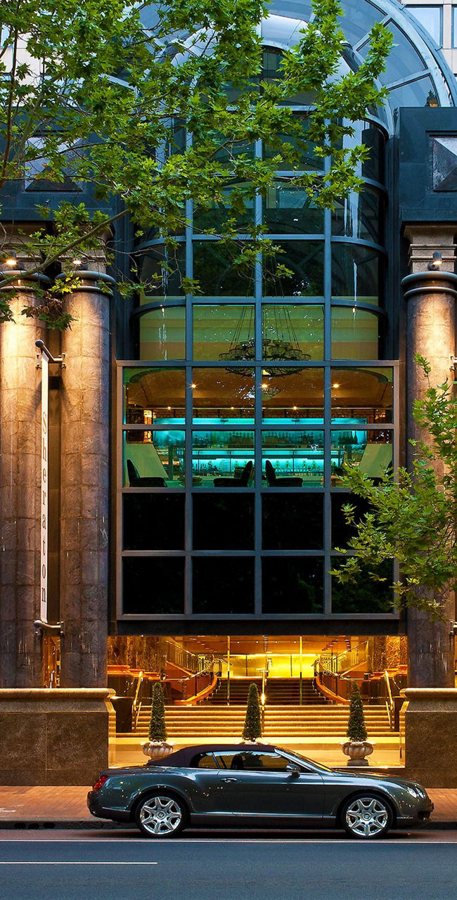 Modern hotel facade with parked cars