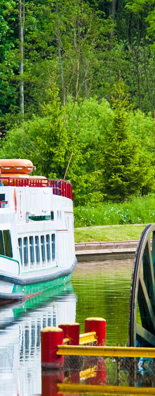 White riverboat docked near water wheel