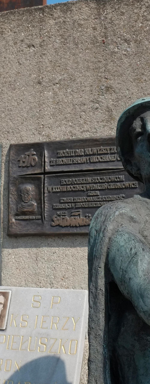 Bronze statue near memorial plaques outdoors