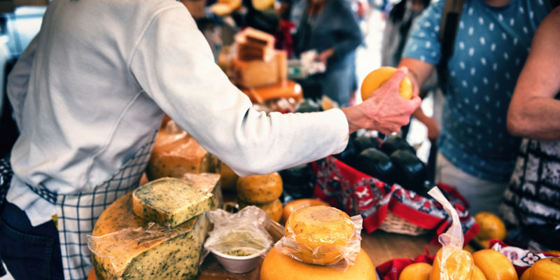 Cheese vendor at outdoor market stall