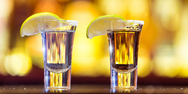 Two cocktail shots with lemon garnish
