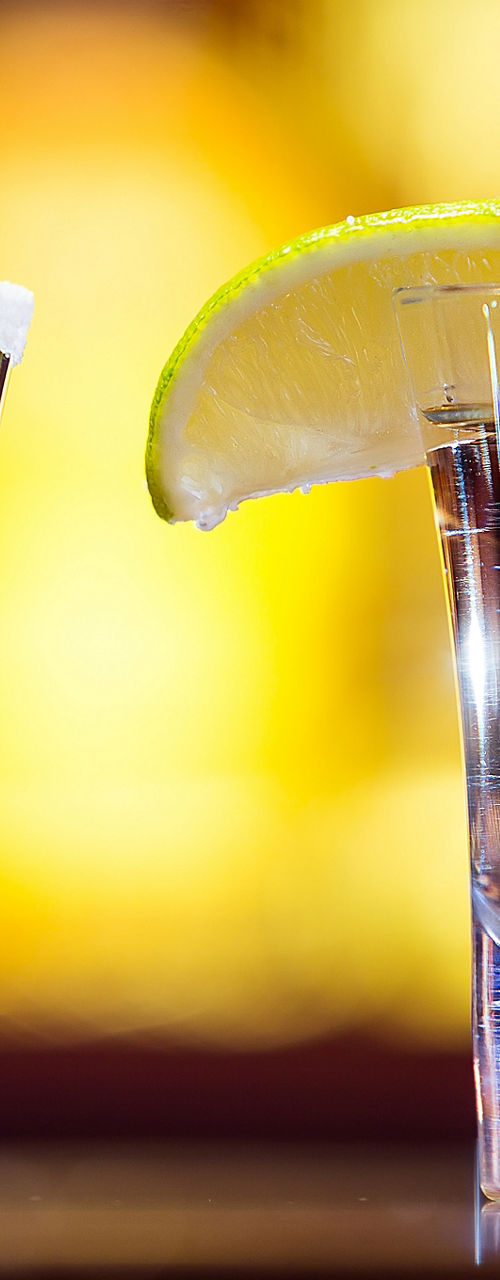 Two cocktail shots with lemon garnish