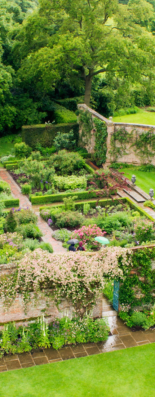 Historic garden with lush greenery and brick house