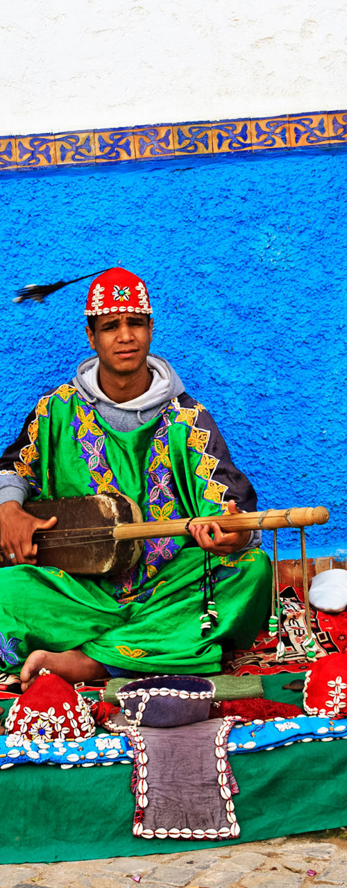 Street musician with traditional crafts display