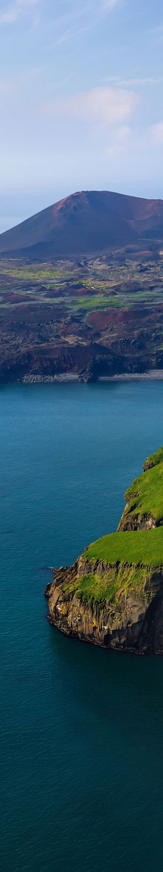 Cruise ship near scenic volcanic coastline