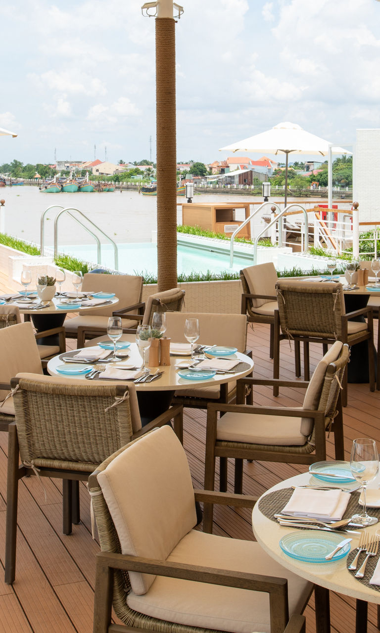 Outdoor riverside dining with poolside view