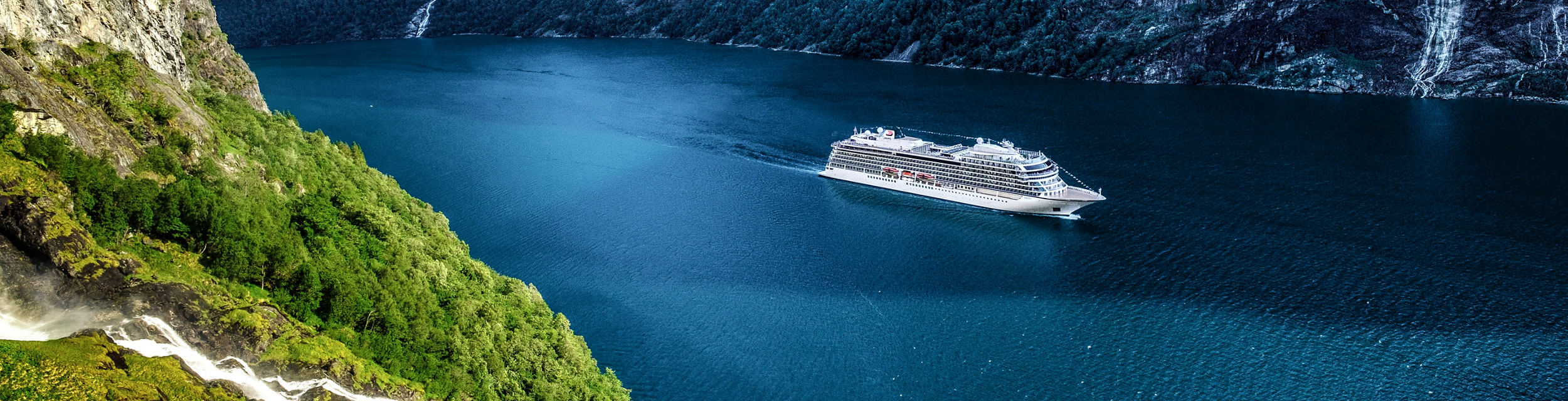 Cruise ship sailing through scenic fjord