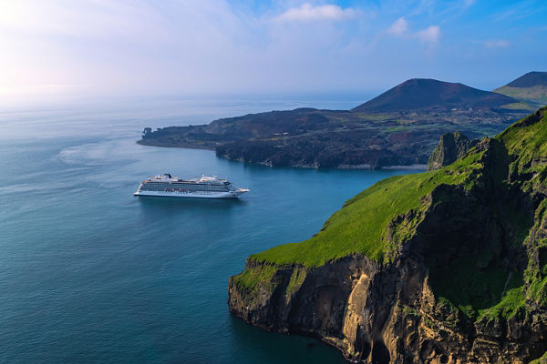 Cruise ship near scenic coastal cliffs