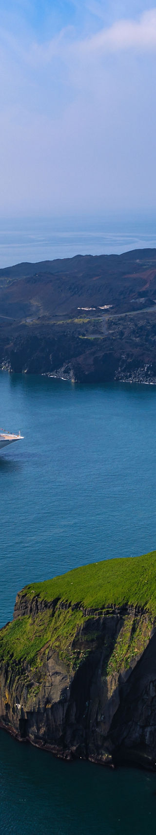 Cruise ship near scenic coastal cliffs