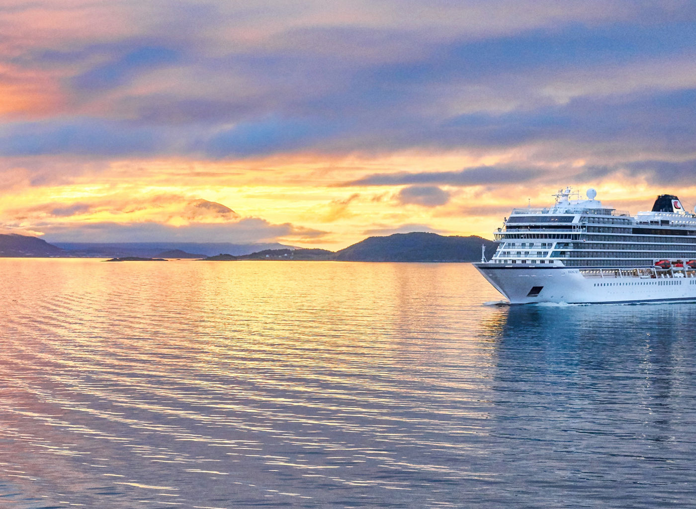 Luxury cruise ship at sunset on calm waters