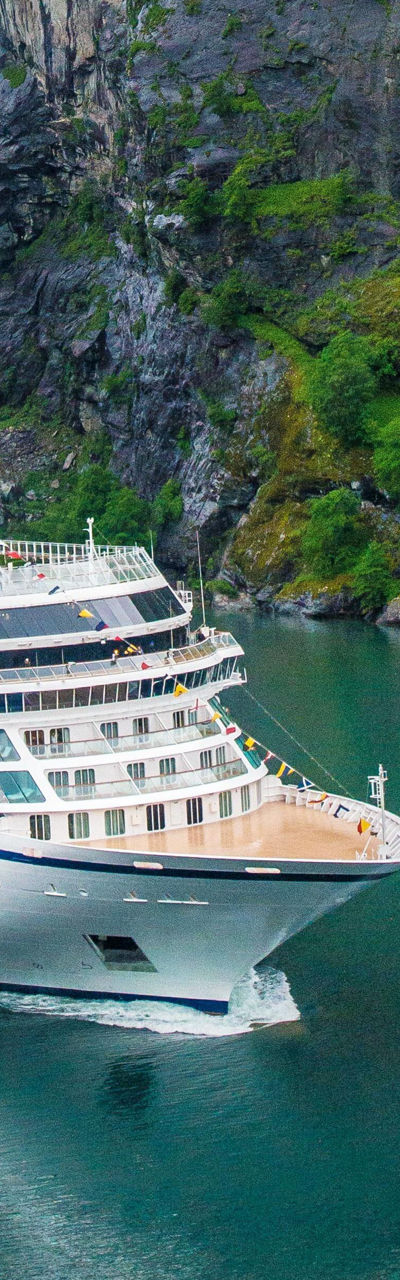Cruise ship near scenic waterfall and cliffs