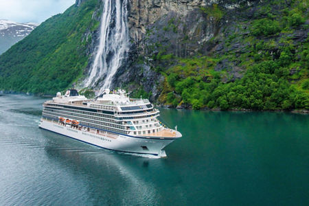 Cruise ship near scenic waterfall and cliffs