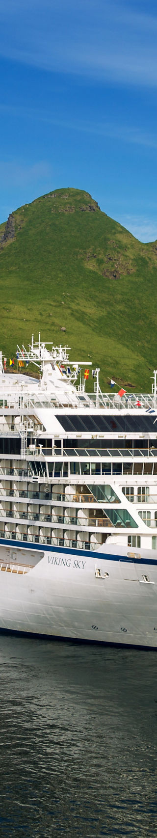 Luxury cruise ship near scenic green cliffs