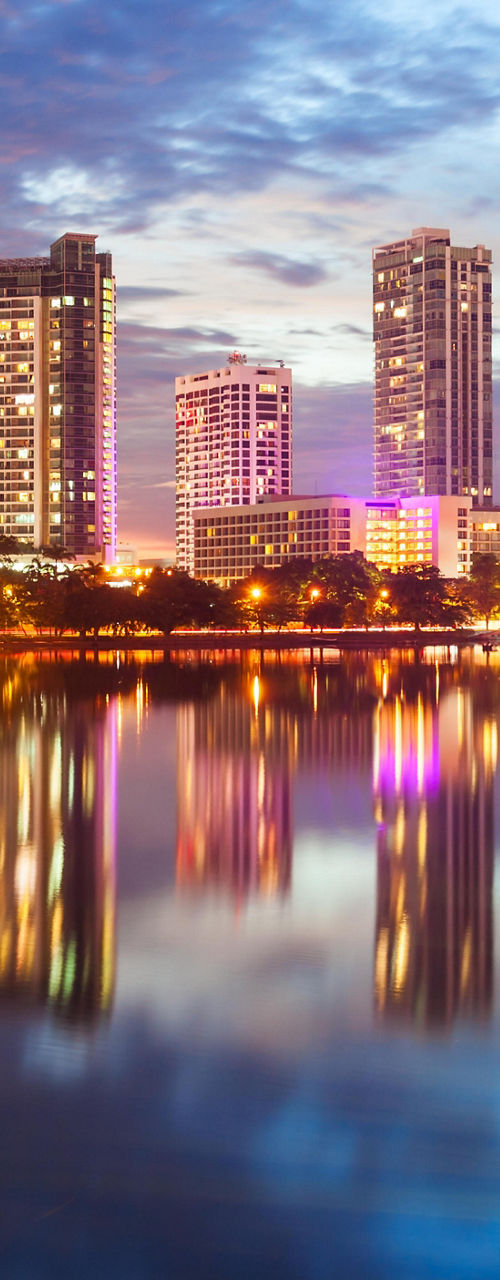 City skyline reflecting on calm lake at dusk
