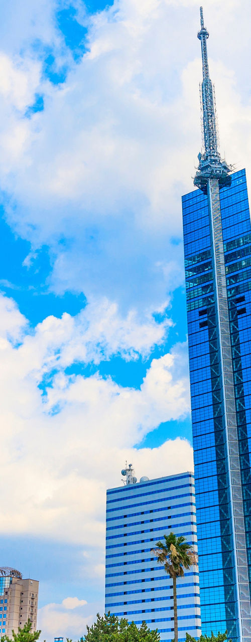 Modern glass skyscraper under bright blue sky