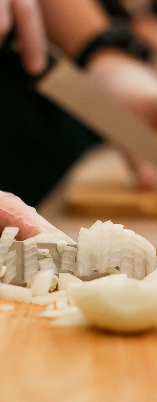 Group chopping onions on wooden cutting boards