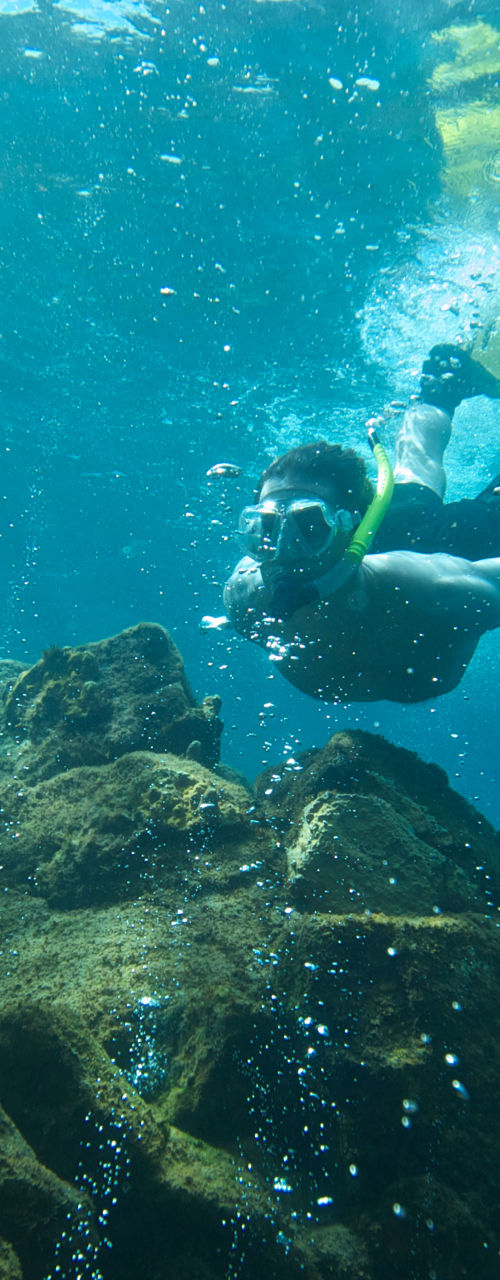 Snorkeler exploring underwater rocky terrain