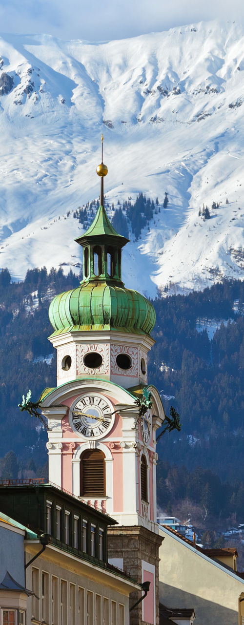 Snowy mountain view with historic clock tower