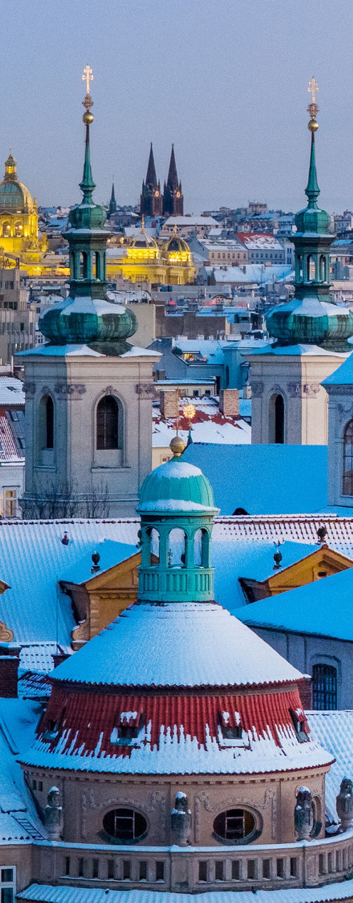 Snow-covered Prague cityscape at dusk