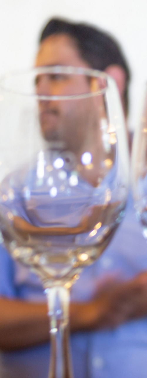 Wine glasses on bar with bottles behind