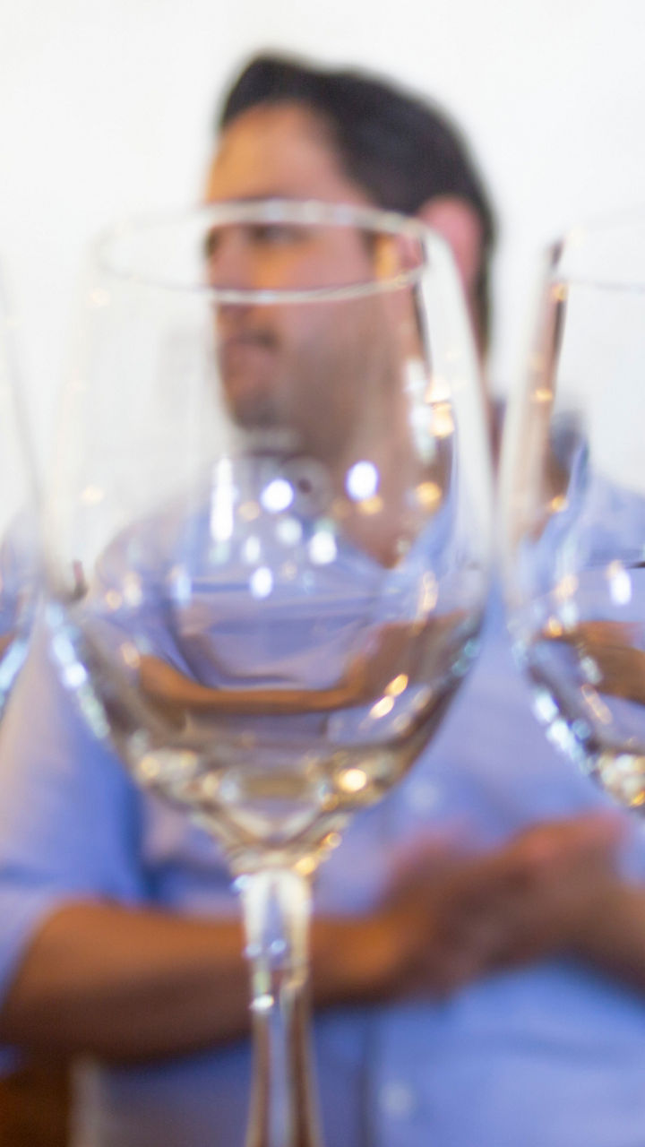 Wine glasses on bar with bottles behind
