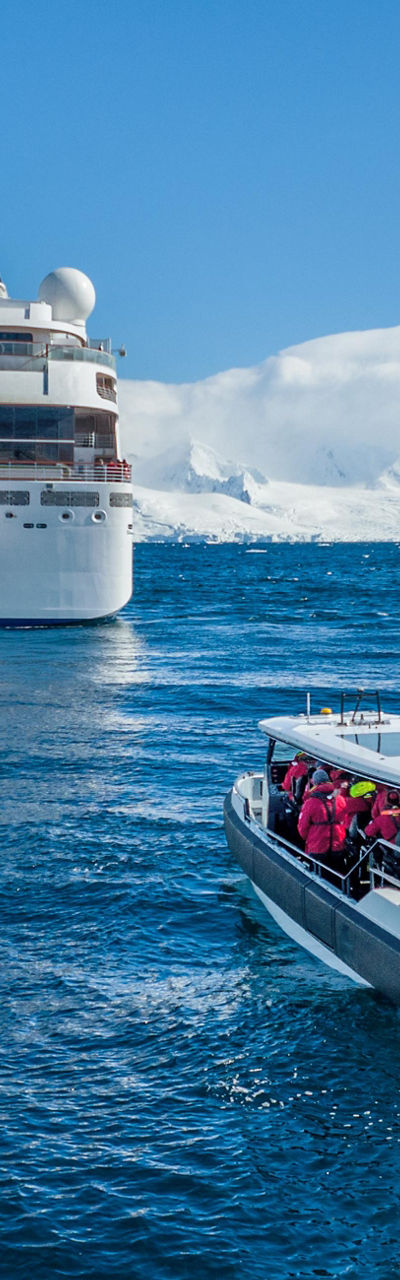 Cruise ship with excursion boat in icy waters