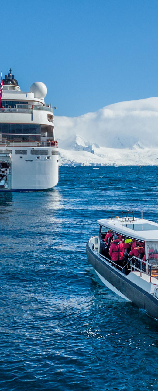 Cruise ship with excursion boat in icy waters