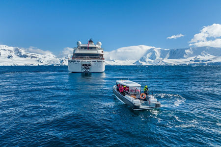 Cruise ship with excursion boat in icy waters