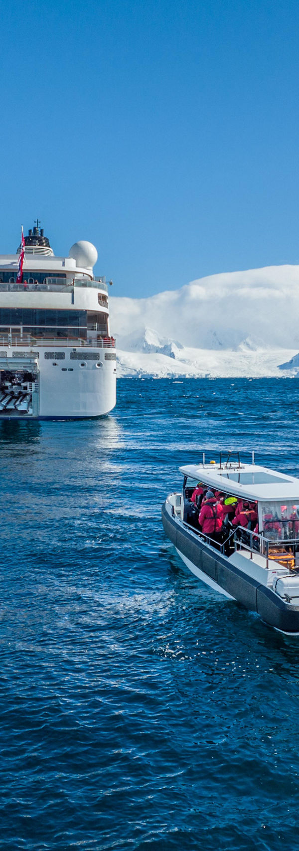 Cruise ship with excursion boat in icy waters