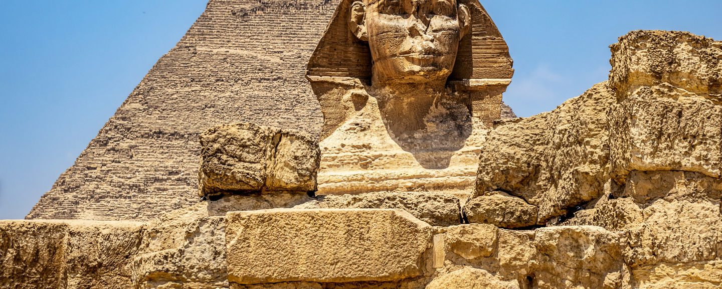 Great Sphinx and Pyramid under blue sky