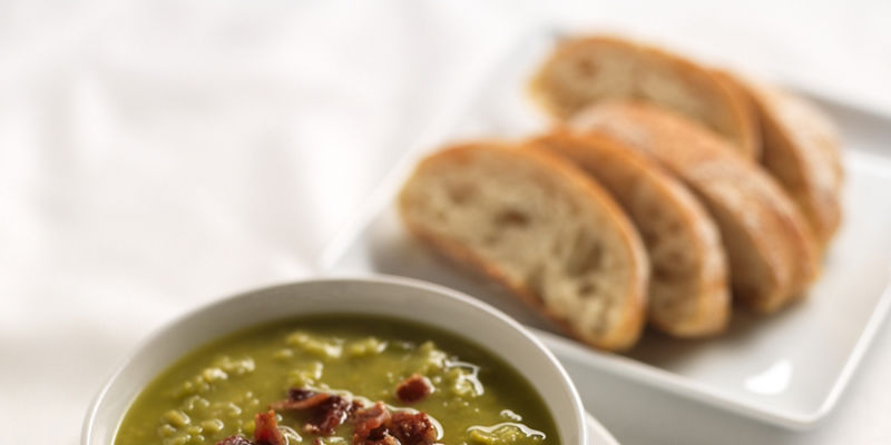 Bowl of pea soup with bacon crumbles