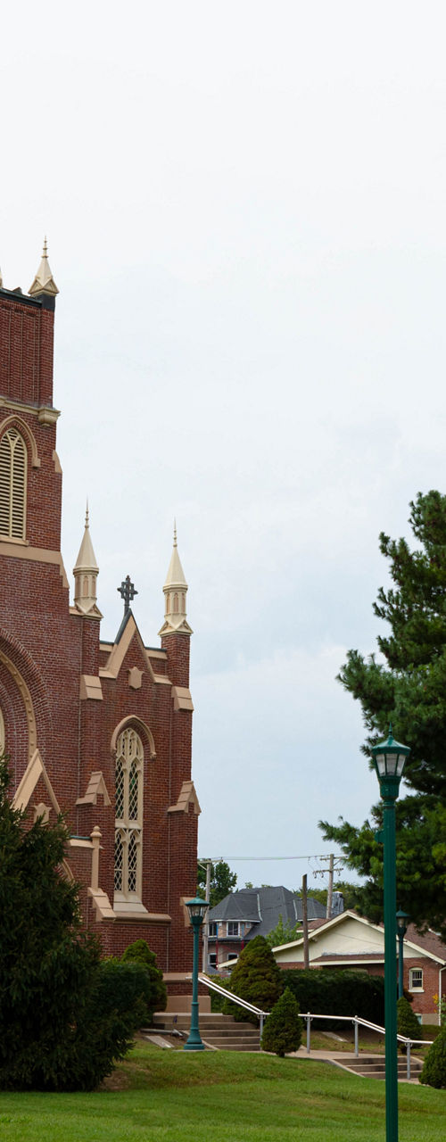 Historic red brick church with green lawn