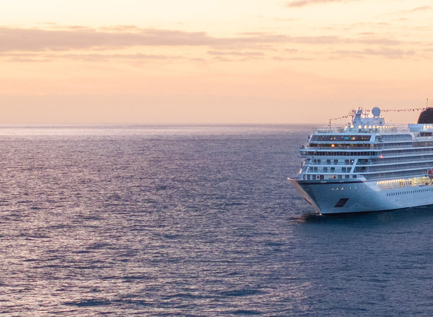 Luxury cruise ship sailing at sunset on open sea