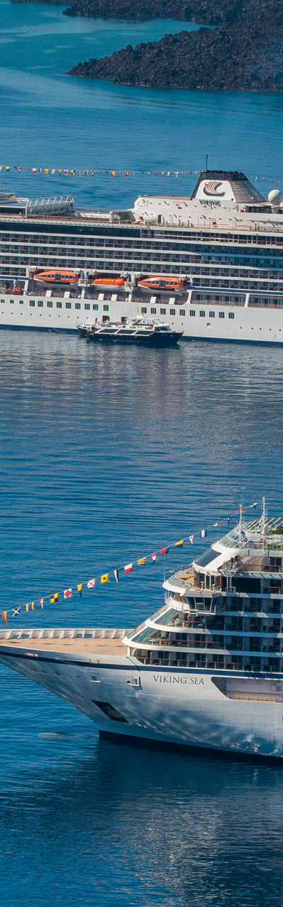 Two large cruise ships anchored near volcanic island
