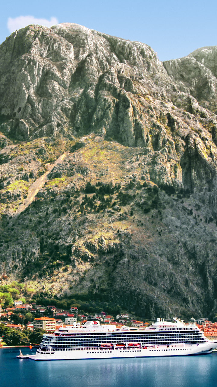Cruise ship near scenic coastal mountains