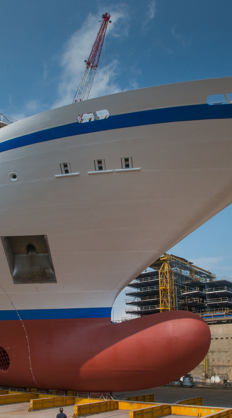 Large cruise ship docked at shipyard under blue sky