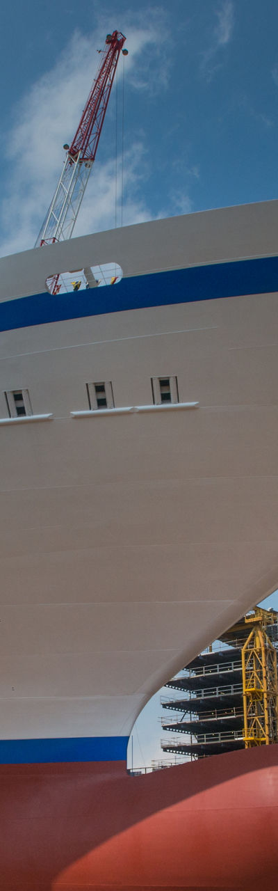 Large cruise ship docked at shipyard under blue sky