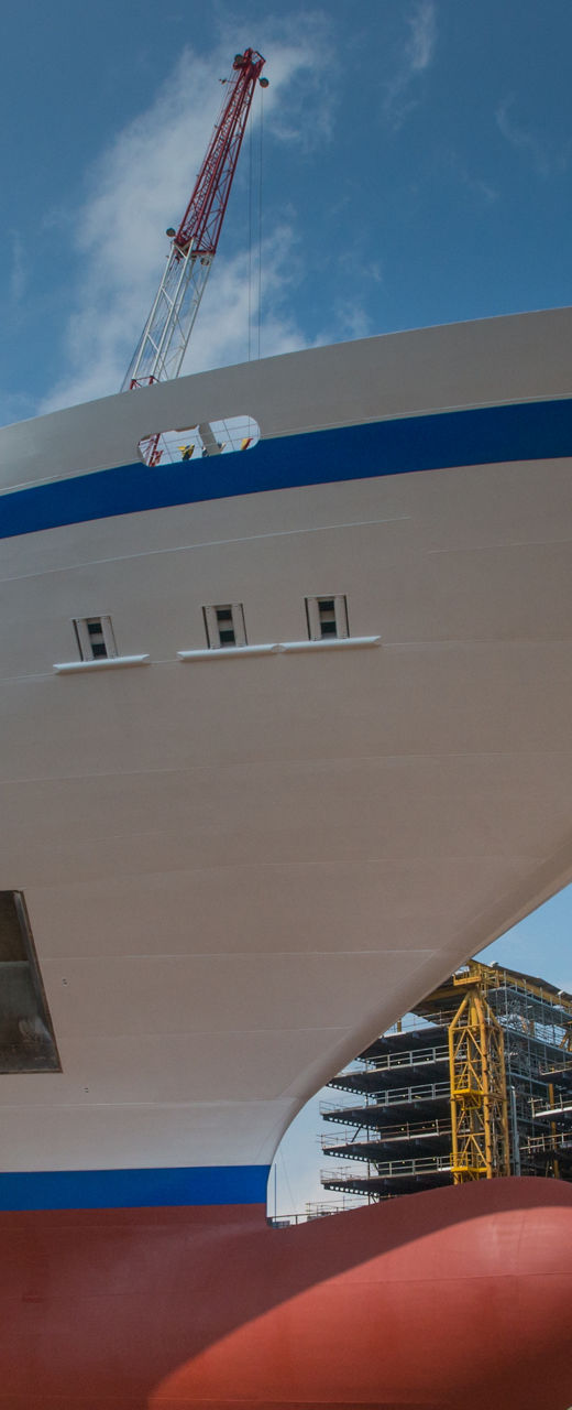Large cruise ship docked at shipyard under blue sky
