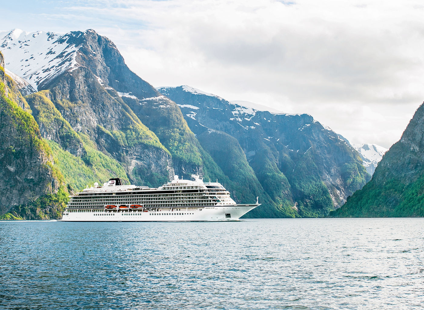 Luxury cruise ship in scenic fjord landscape