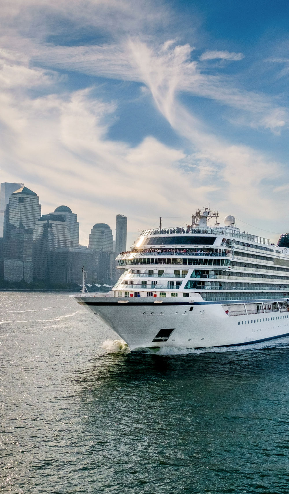Luxury cruise ship sailing near city skyline