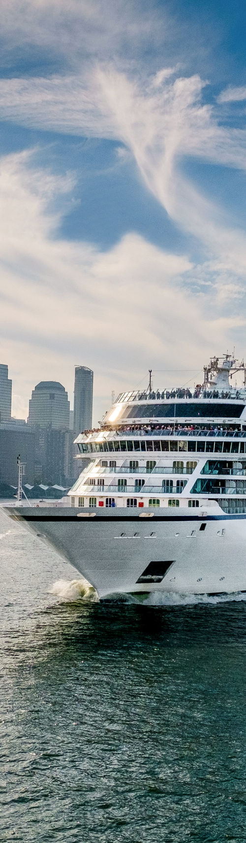 Luxury cruise ship sailing near city skyline