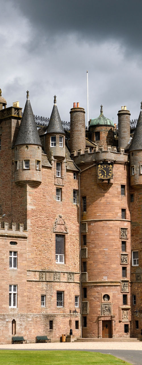 Historic stone castle with foreground statue