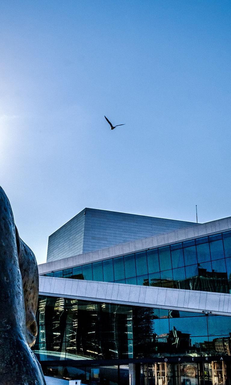 Bronze statue near modern glass building